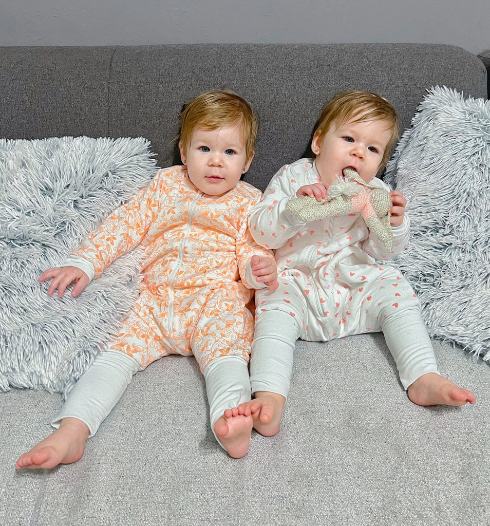 Két kislány liaabéb hálózsákban ül a kanapén